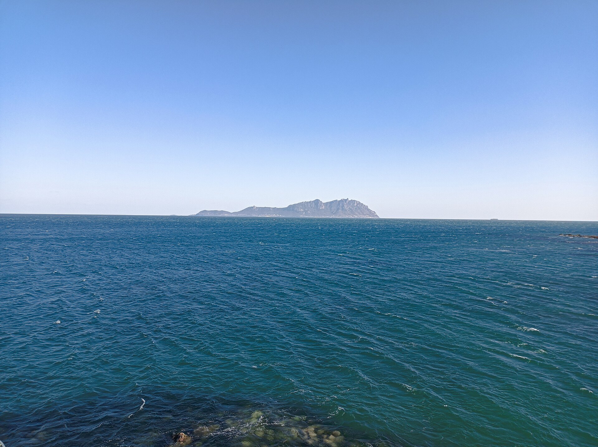 从灵山湾海面远眺灵山岛，蓝天碧海中一座青色岛影